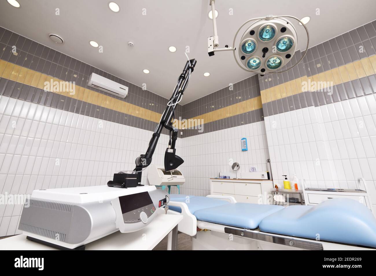 Fraktionenlaser vor dem Hintergrund eines modernen Operationssaals in einer Kosmetik- oder dermatologischen Klinik. Stockfoto