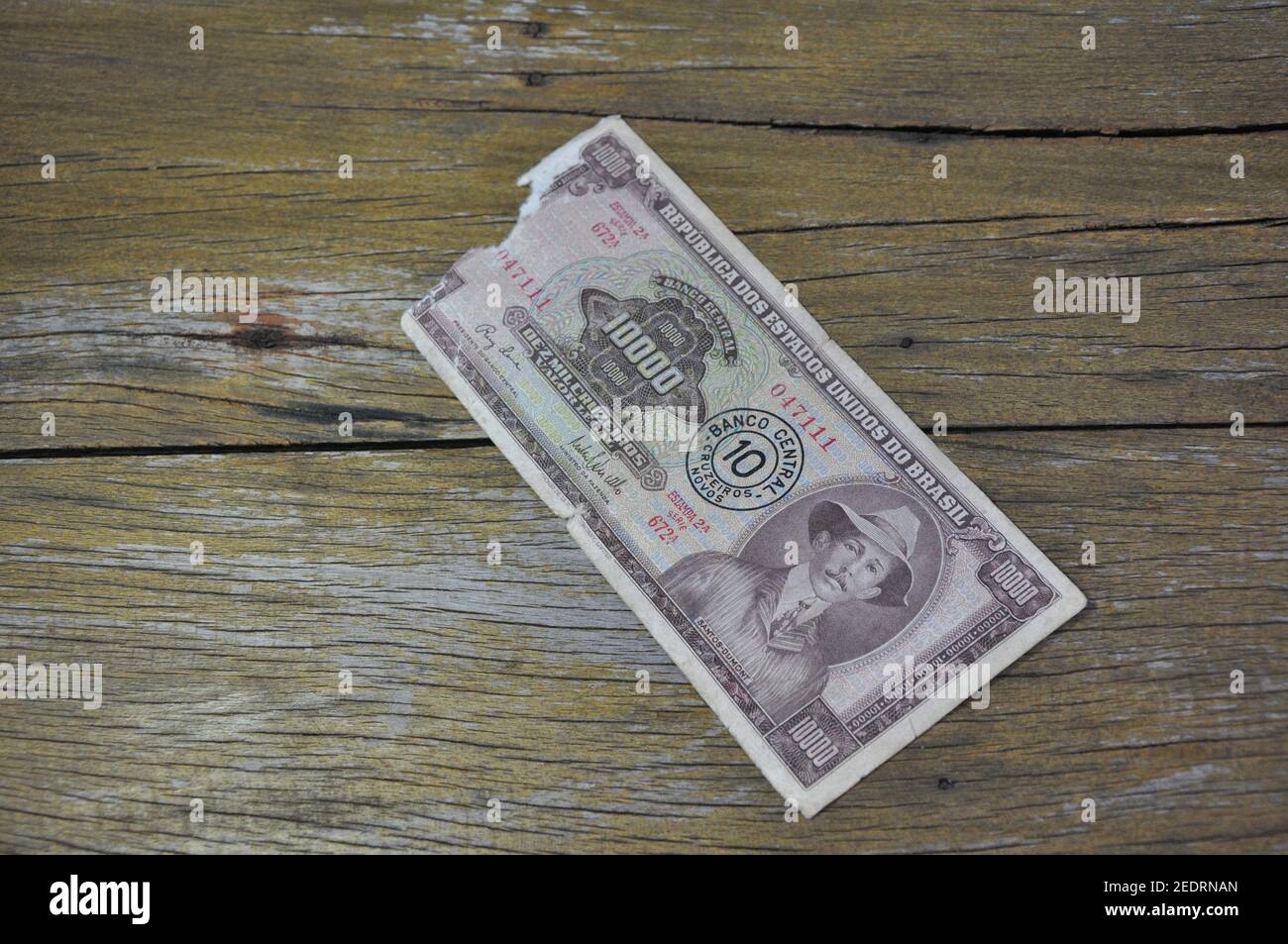 Papiergeld, zehntausend Kreuzfahrten, mit zehn neuen Kreuzfahrten Stempel, Portraitdruck von Santos Dumont, Erfinder des Flugzeugs, Holzhintergrund, Kopie Stockfoto