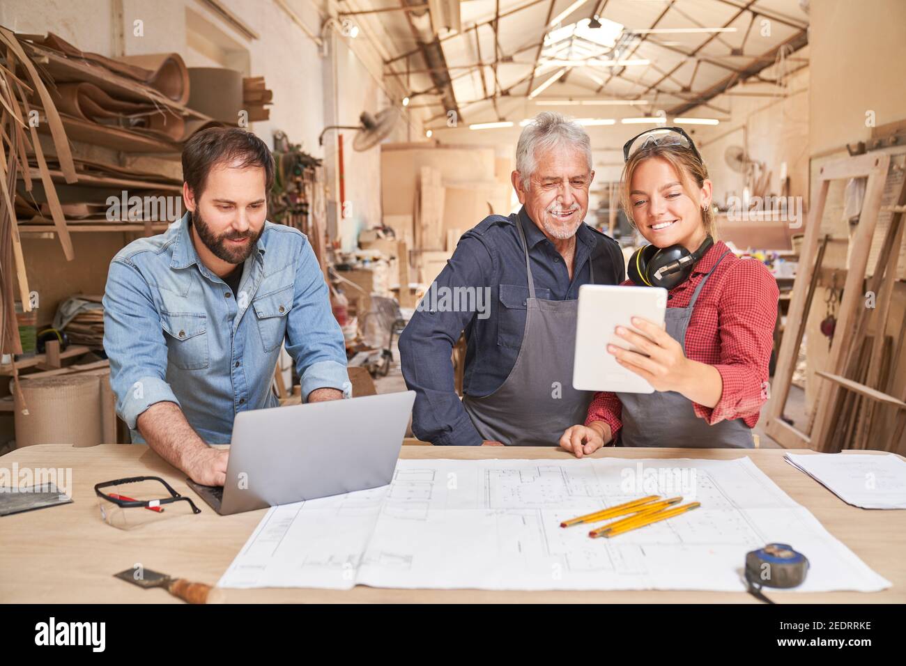 Handwerker Team mit Computern in einer Tischlerwerkstatt in einem Mittelständisches Handwerksunternehmen Stockfoto