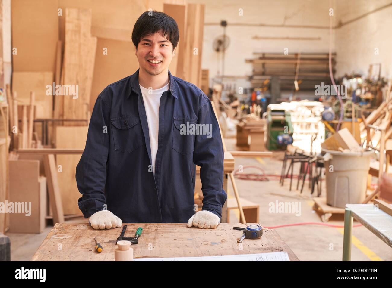 Der junge Mann macht eine handwerkliche Ausbildung zum Zimmermann Die Schreinerei Stockfoto