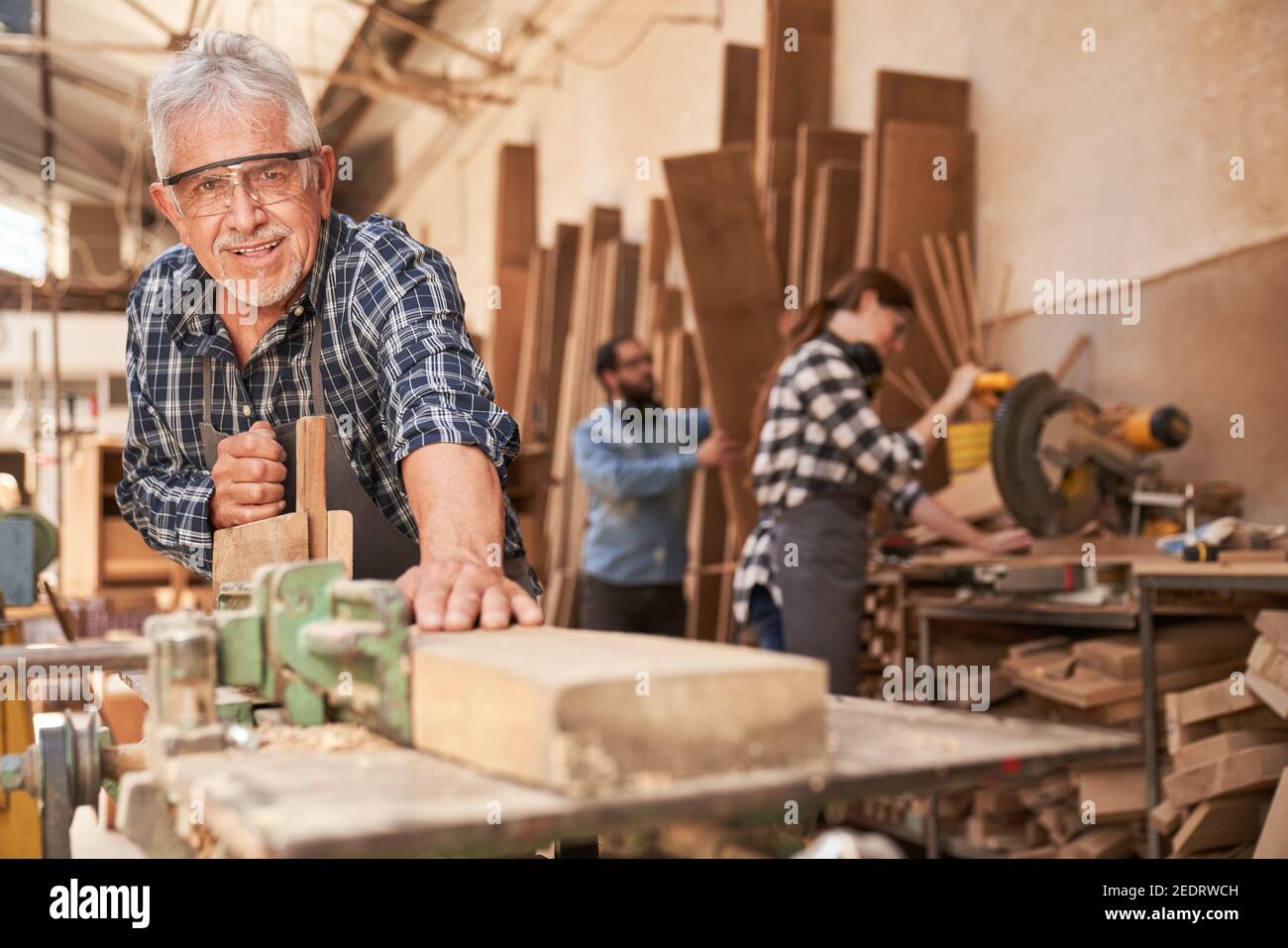 Handwerker als erfahrener Hobelmeister Holz in der Schreinerei Stockfoto