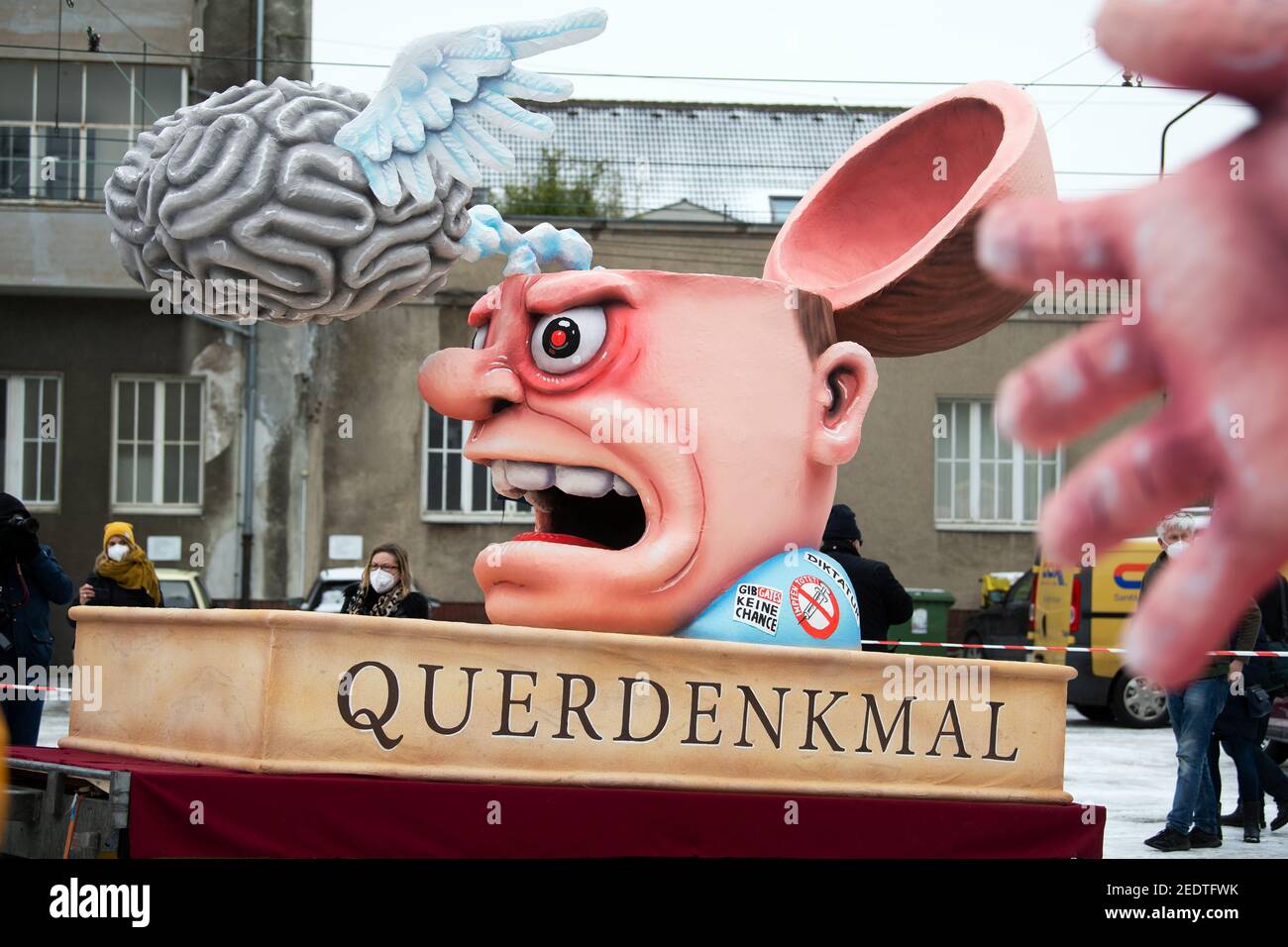 Düsseldorf, Deutschland. Februar 2021, 15th. Vor der Floatbauhalle ist ein Motto-Float mit einer Figur mit geöffnetem Schädel, darüber ein Gehirn mit Flügeln und die Inschrift Querdenkmal zu sehen. Die Düsseldorfer Fleischfreund schickten am Rosenmontag acht ihrer berühmten "otto-Wagen" auf die Straße. Aufgrund der Pandemie sollten die überlebensgroßen Karikaturen nicht als Prozession durch die Stadt Rollen, sondern getrennt. Die Route blieb streng geheim, um Menschenmassen zu vermeiden. Quelle: Federico Gambarini/dpa/Alamy Live News Stockfoto