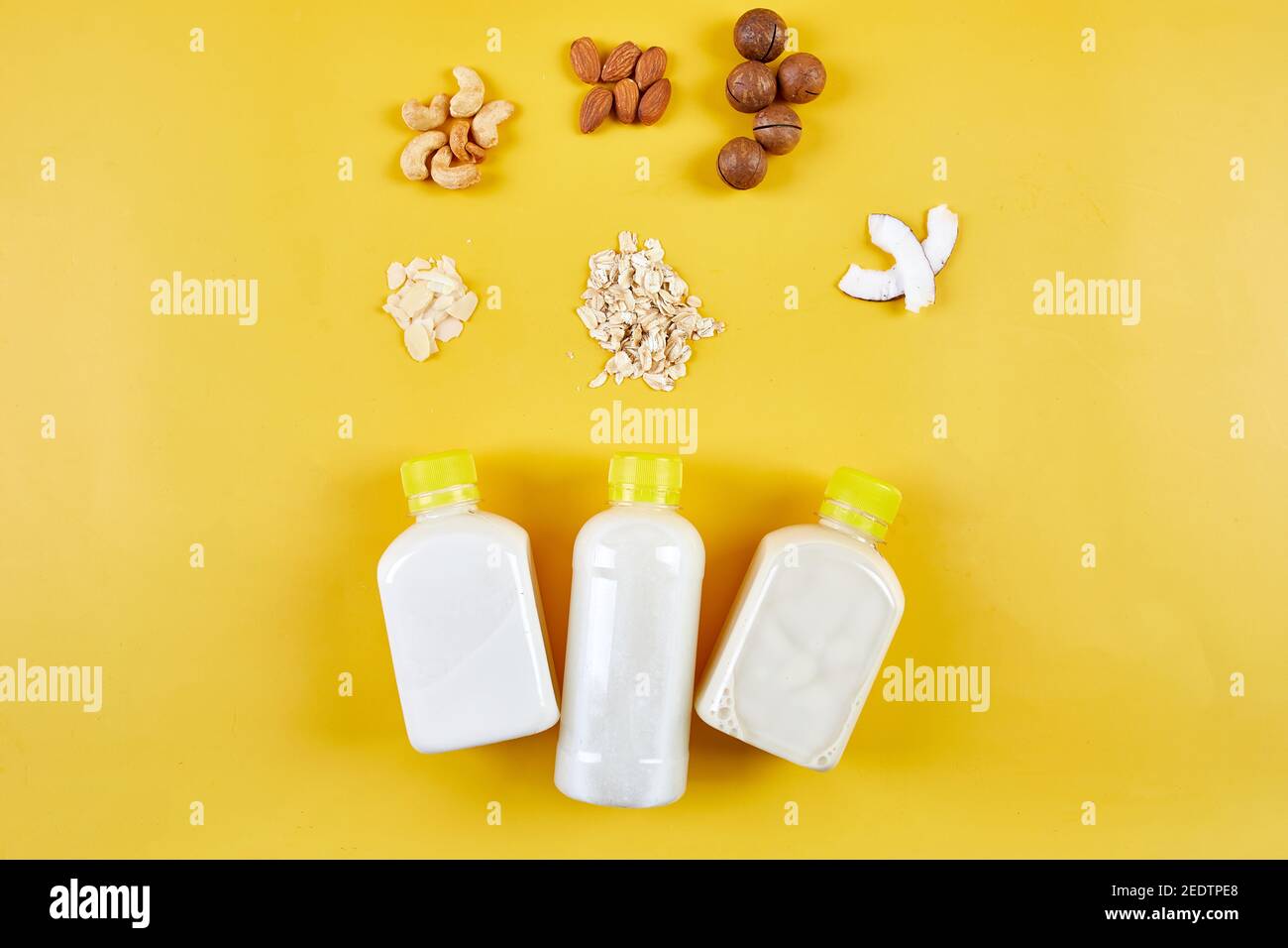 Alternative Arten von veganen Milch in Flaschen auf einem gelben Hintergrund Stockfoto