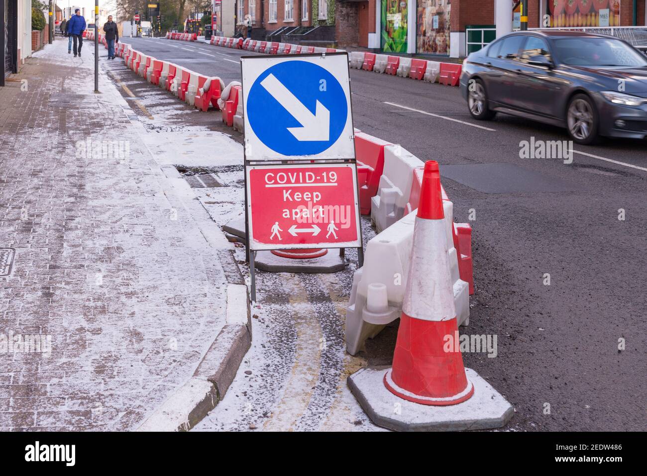 Covid-19 soziale Distanzierung Zeichen an verbreiterten Bürgersteig in Harborne, Birmingham Stockfoto
