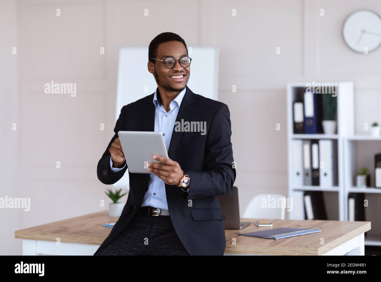 Fröhliche afroamerikanische junge Geschäftsmann mit digitalen Tablet im Büro Stockfoto