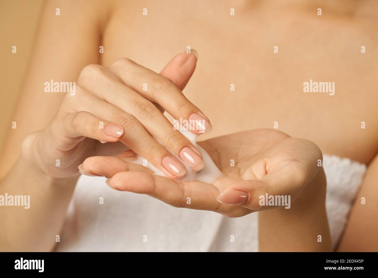 Nahaufnahme der Hände der Frau Vorbereitung auf sanfte Schaum Gesichtsreiniger gelten. Beauty-Produkte und Hautpflege-Konzept Stockfoto