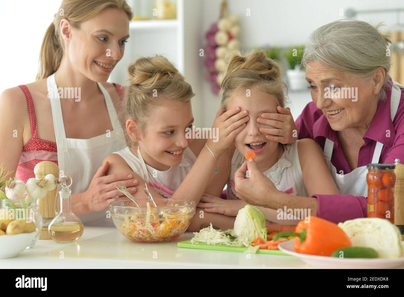 Nette Mädchen mit Mutter und Großmutter, die köstlichen frischen Salat Stockfoto
