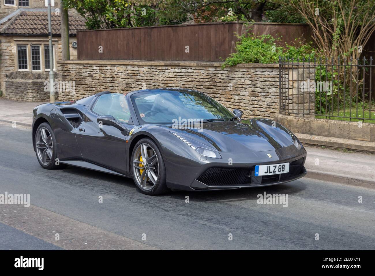 Ein metallisch grauer Ferrari 488 GTS aka 488 GTB Spider, mit einem personalisierten Nummernschild, der durch das Dorf Yatton Kennel in der Nähe des Schlosses fährt Stockfoto