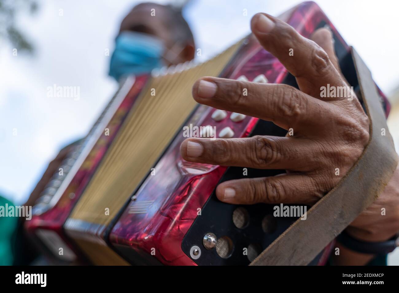 Musiker in einer schützenden Gesichtsmaske spielen Akkordeon im Freien Stockfoto