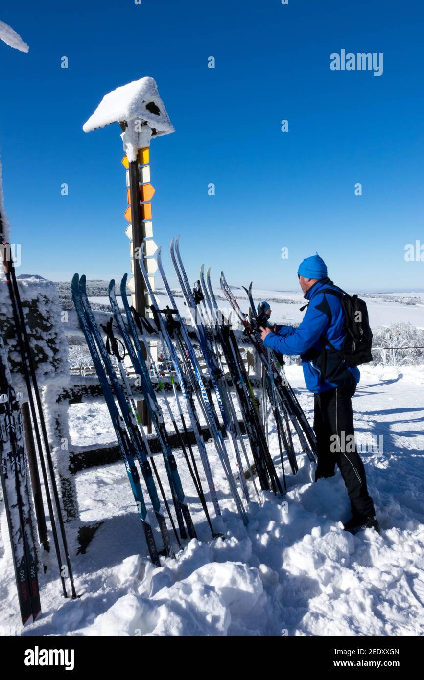 Ein Mann legt Ski in einen Skiständer Stockfoto