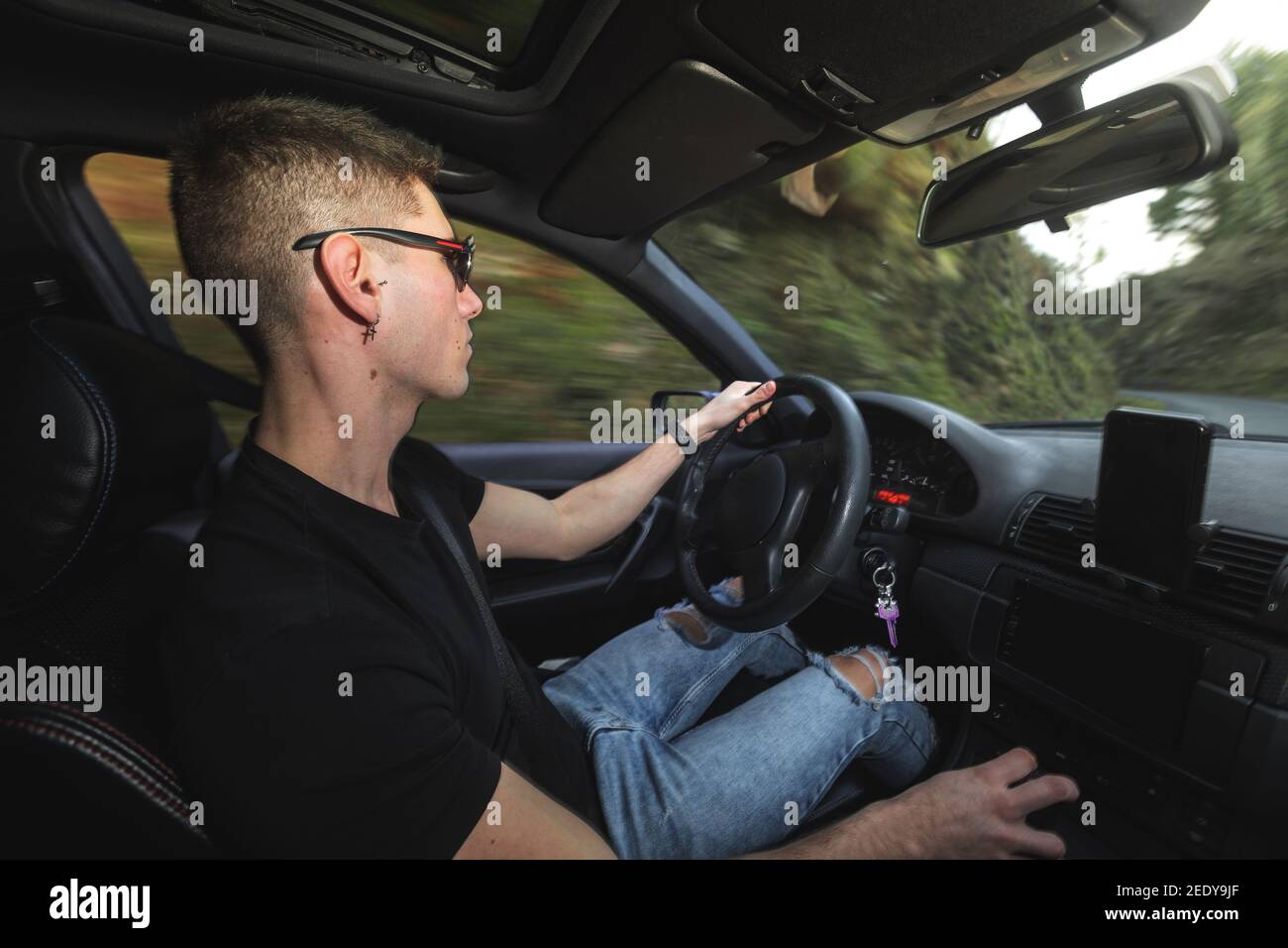 Junger Kaukasier, der einen Sportwagen fährt Stockfoto