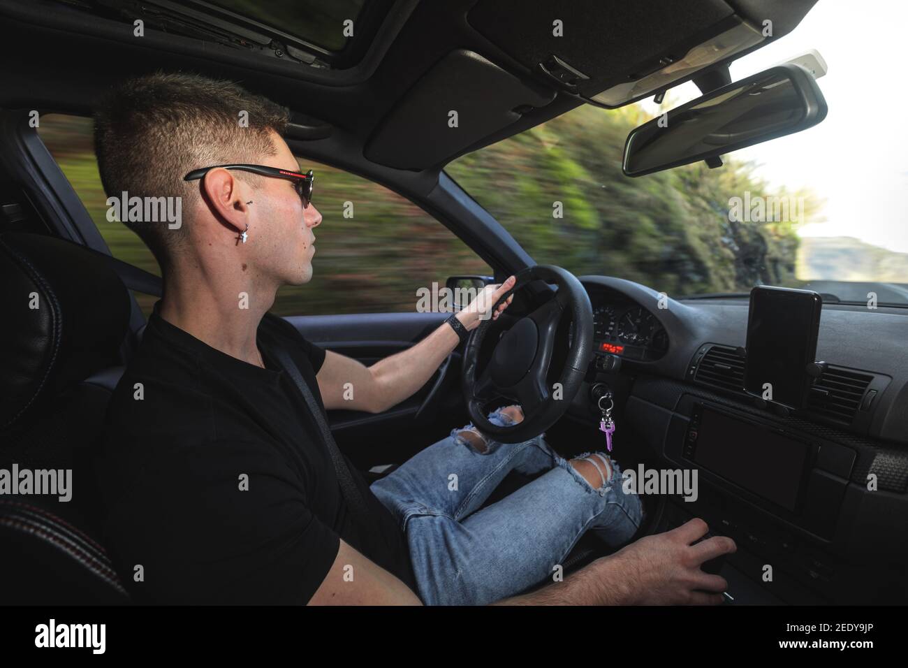 Junger Kaukasier, der einen Sportwagen fährt Stockfoto