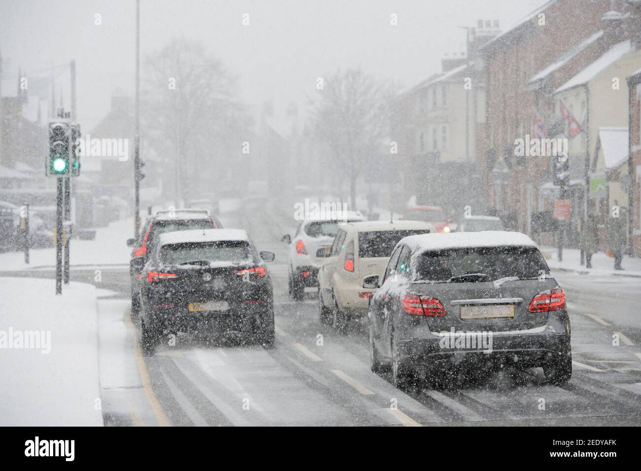 Fahrzeuge fahren bei verschneiten Wetter in Market Harborough, Leicestershire, East Midlands, England. Stockfoto