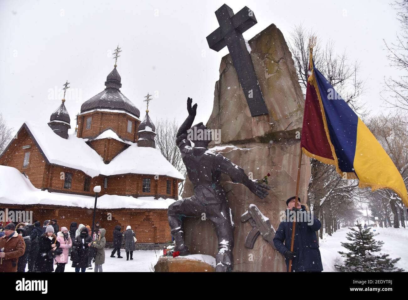 Ein Mann hält eine Fahne in der Nähe des Denkmals für Ukrainer, die in Afghanistan während der sowjetischen Aggression in den Jahren 1979-1989 getötet wurden.EINE Gedenkveranstaltung zum 32nd. Jahrestag des Endes des sowjetisch-afghanischen Krieges in der westukrainischen Stadt. Stockfoto