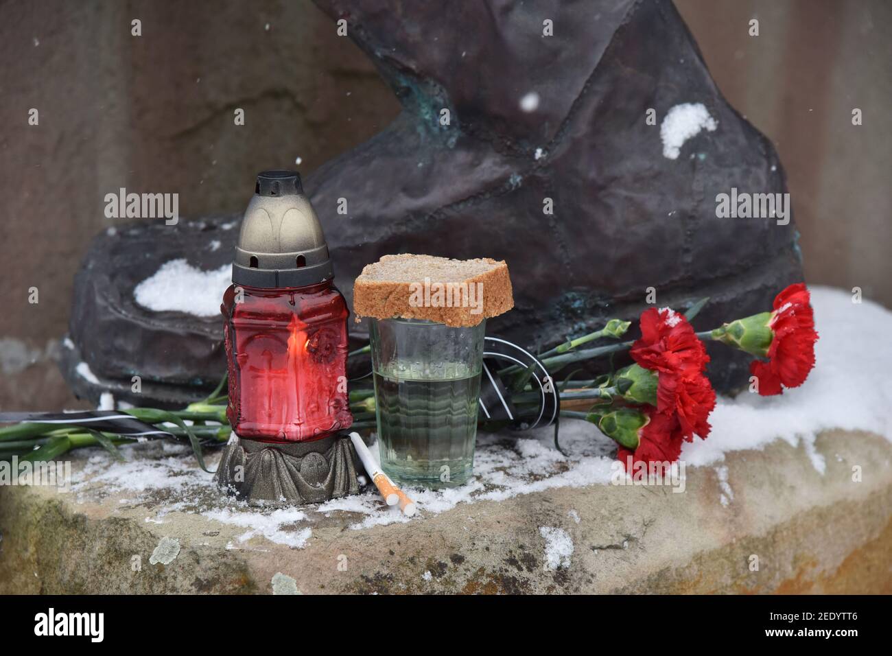 Eine Lampe, Blumen, Zigaretten und ein Glas Wodka, bedeckt mit einer Scheibe Brot, am Fuße des Denkmals für Ukrainer, die 1979-1989 während der sowjetischen Aggression in Afghanistan ums Leben kamen.GEDENKVERANSTALTUNGEN zum 32nd. Jahrestag des Endes des sowjetisch-afghanischen Krieges in der westukrainischen Stadt. Stockfoto