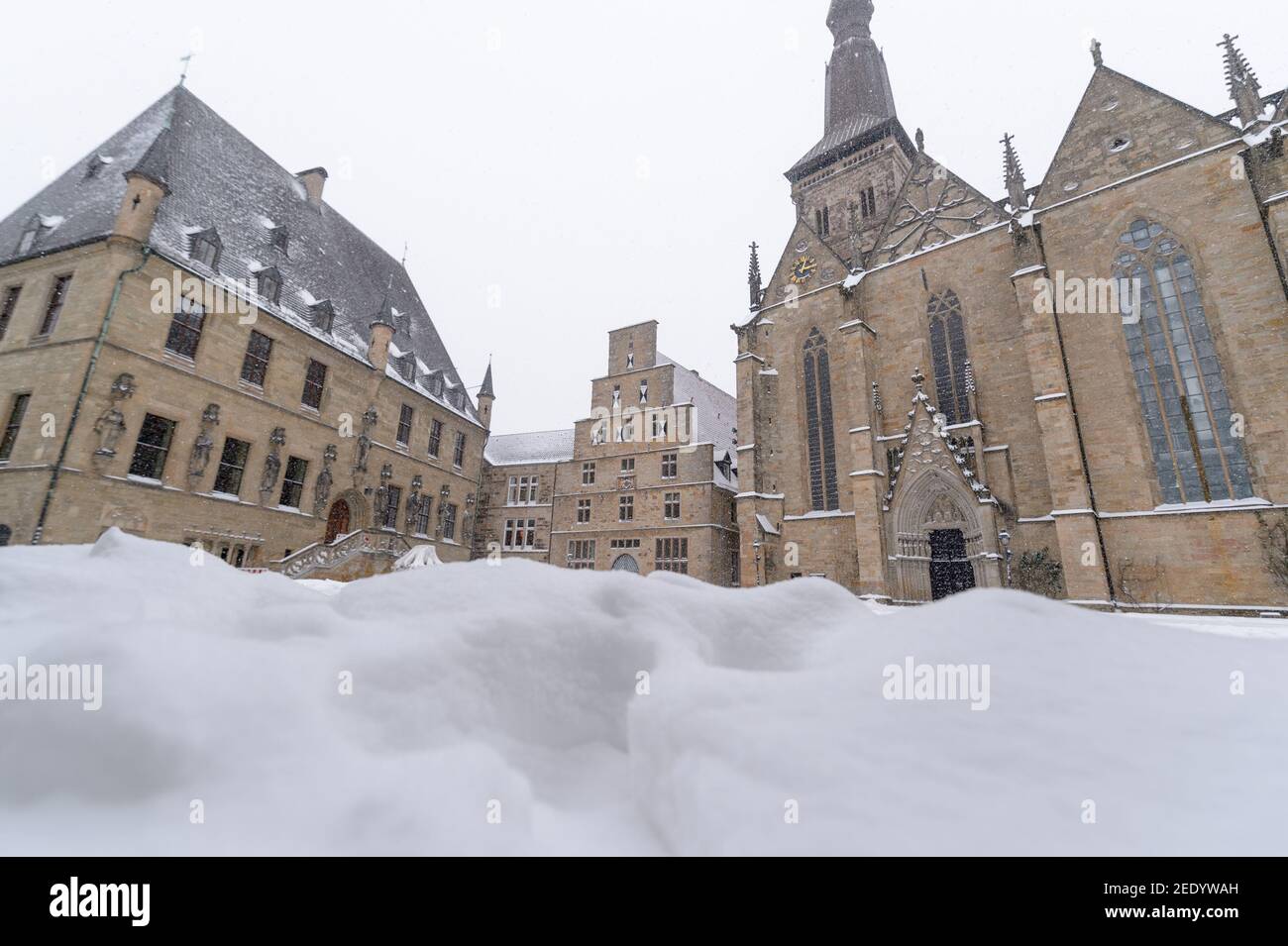 08. Februar 2021, Niedersachsen, Osnabrück: Das historische Rathaus, das Standesamt und die Marienkirche auf dem verschneiten Marktplatz. Foto: Jonas Walzberg/dpa Stockfoto