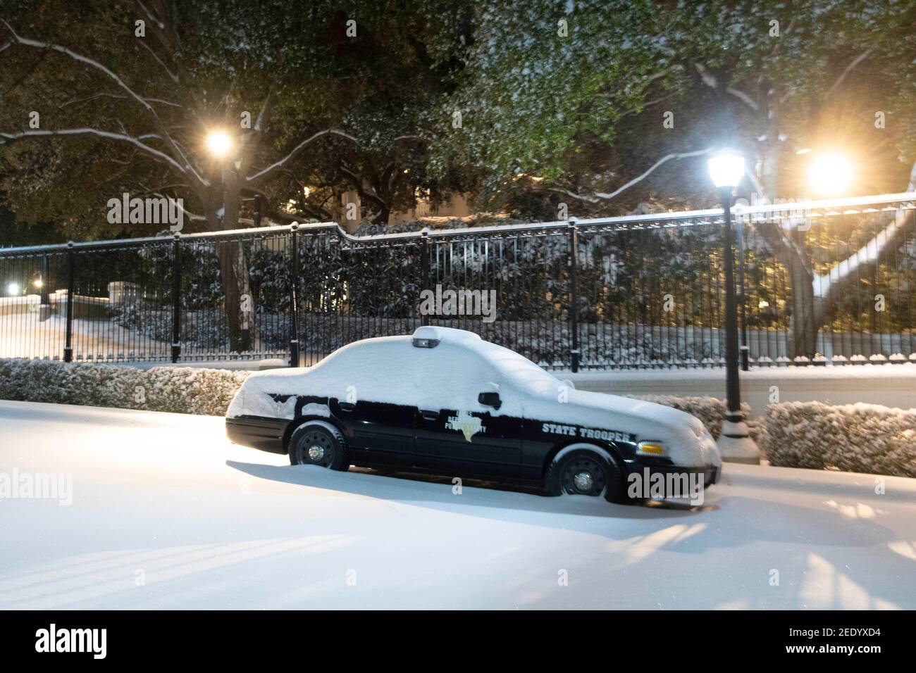 Austin, Texas USA 15. Feb. 2021: Ein texanischer Staatstruppenwagen sitzt vor dem Governor's Mansion, als ein seltener Winterschnee von mindestens einem halben Fuß das Zentrum von Texas trifft. Austin, Texas USA 15. Feb 2021: Das Texas Capitol Gelände einschließlich des südlichen Gehwegs ist von 6-7 Zoll seltenen Schneefall am Montagmorgen bedeckt, nachdem ein Wintersturm über Nacht in Zentral-Texas geweht hat. Das damit einhergehende frigide Wetter verursachte verheerende Schäden am staatlichen Stromnetz und verursachte massive Stromausfälle für Millionen von Kunden im ganzen Land. Kredit: Bob Daemmrich/Alamy Live Nachrichten wie das State Capitol und der Kongreß Stockfoto