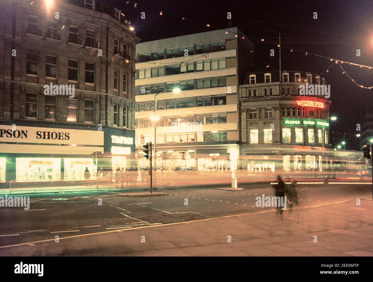 1975 Shefffield - Verkehr an der Kreuzung von Pinstone Street und Leopold Street Sheffield City Centre. WILSON PECK, „die Heimat der Musik“, hat die Ehre, Sheffield’s längster Plattenladen zu sein. Es war 1896 geöffnet, und die beiden Gründer Arthur Wilson (ein Pseudonym) und John Peck waren schon seit einigen Jahren im Geschäft mit dem Verkauf von Klavieren. Es ist jetzt H L Brown Jewelers.Timpson Schuhe besetzten das Gebäude gegenüber, jetzt Barclays Bank, aber früher Wilson Peck! Sheffield City Centre South Yorkshire England GB Großbritannien Europa Stockfoto