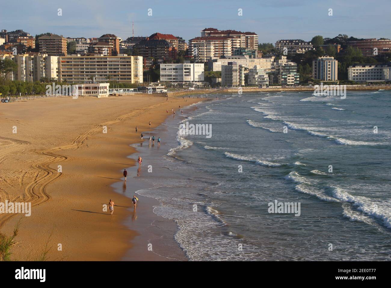 Zweiter Strand Sardinero Santander Cantabria Spanien an einem sonnigen Frühlingsmorgen mit Spaziergängern und surfen in der Bar Cormorant, Restaurant und Wohnungen Stockfoto