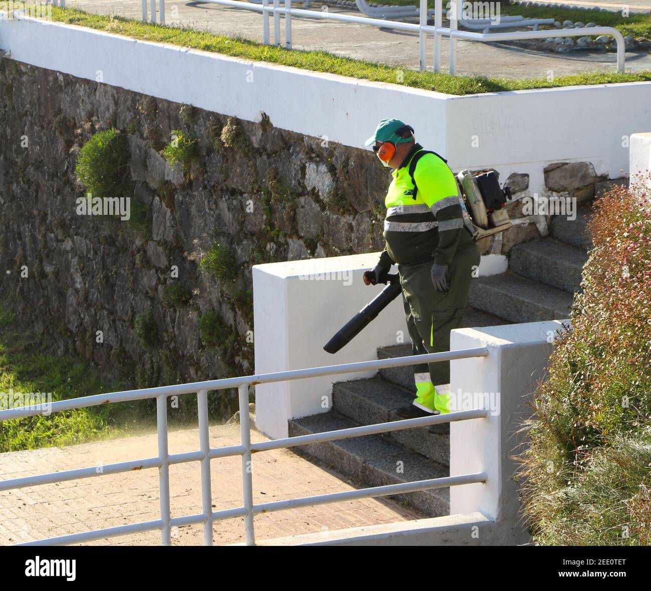 Ein Mitarbeiter des Stadtrats, der ein Laubgebläse auf einer Treppe in den Gärten von Piquio verwendet, befindet sich neben den Stränden von Sardinero Santander Cantabria Spanien Stockfoto