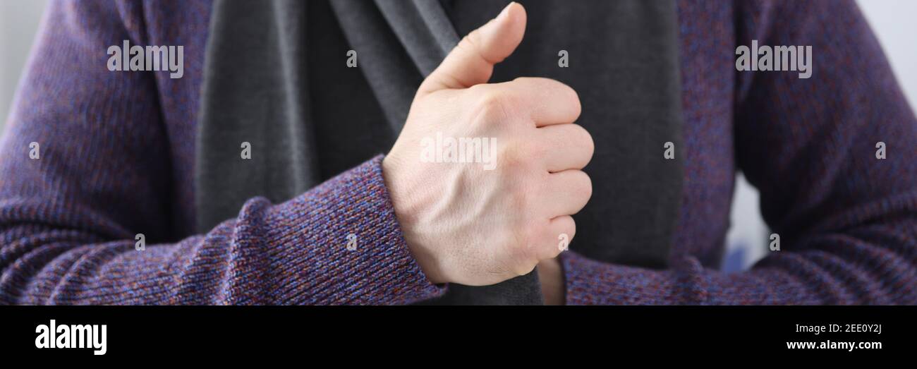 Mann in Strickpullover Puting auf warmen Schal Nahaufnahme Stockfoto