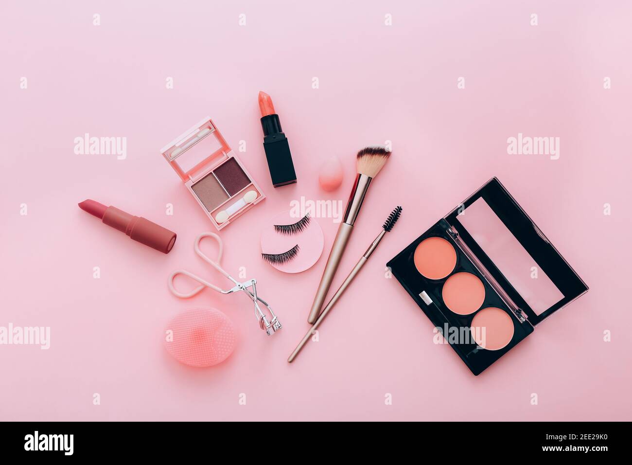 Weibliche Accessoires für Make-up auf rosa Hintergrund. Schönheitskonzept. Stockfoto