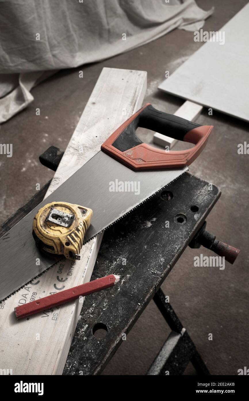 Handsäge, Maßband und Bleistift auf einem Stück Schnittholz. Stockfoto