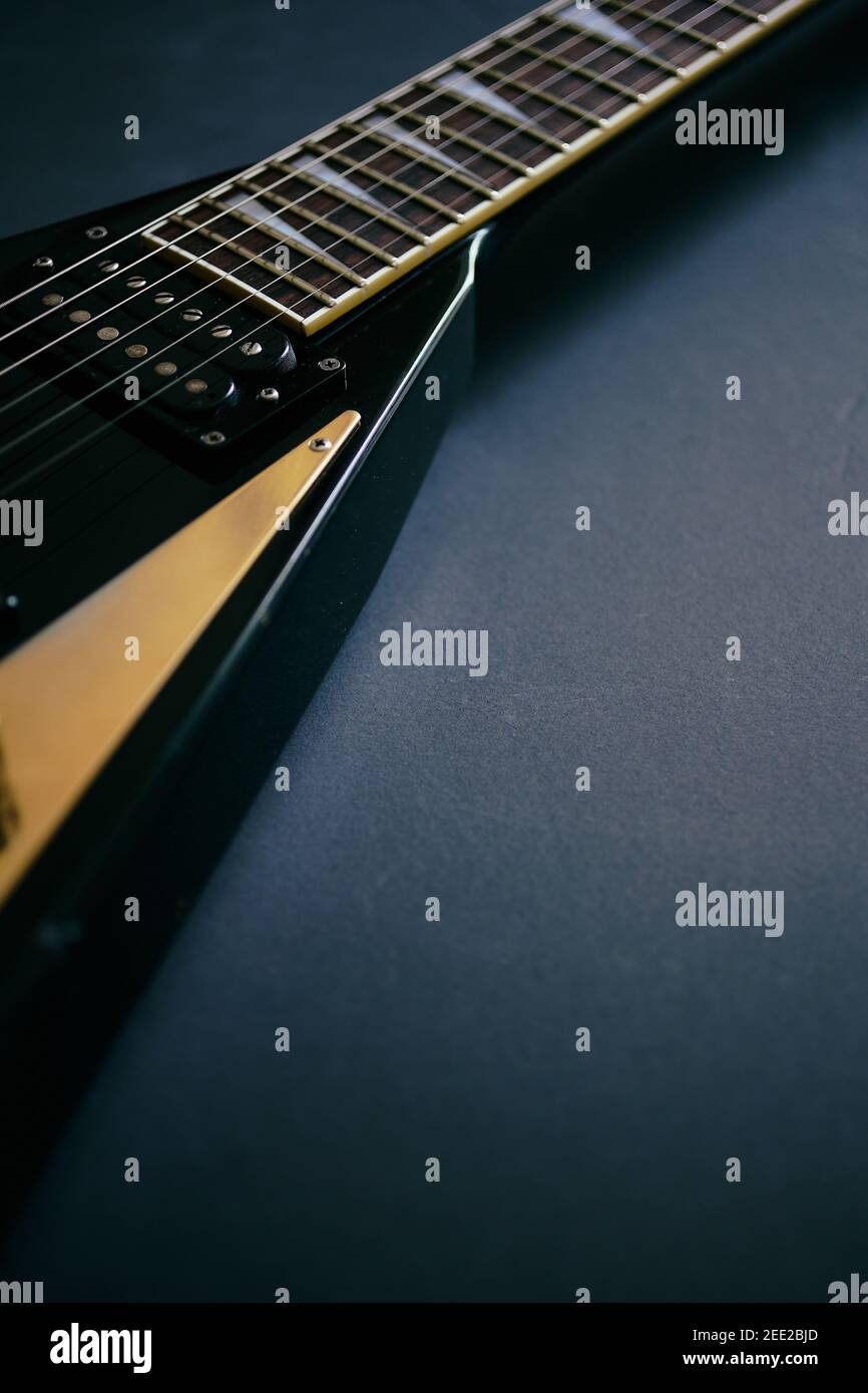 Crop Soft Fokus Schuss von schwarzen V-Form E-Gitarre Auf dunklem Grunge-Hintergrund Stockfoto