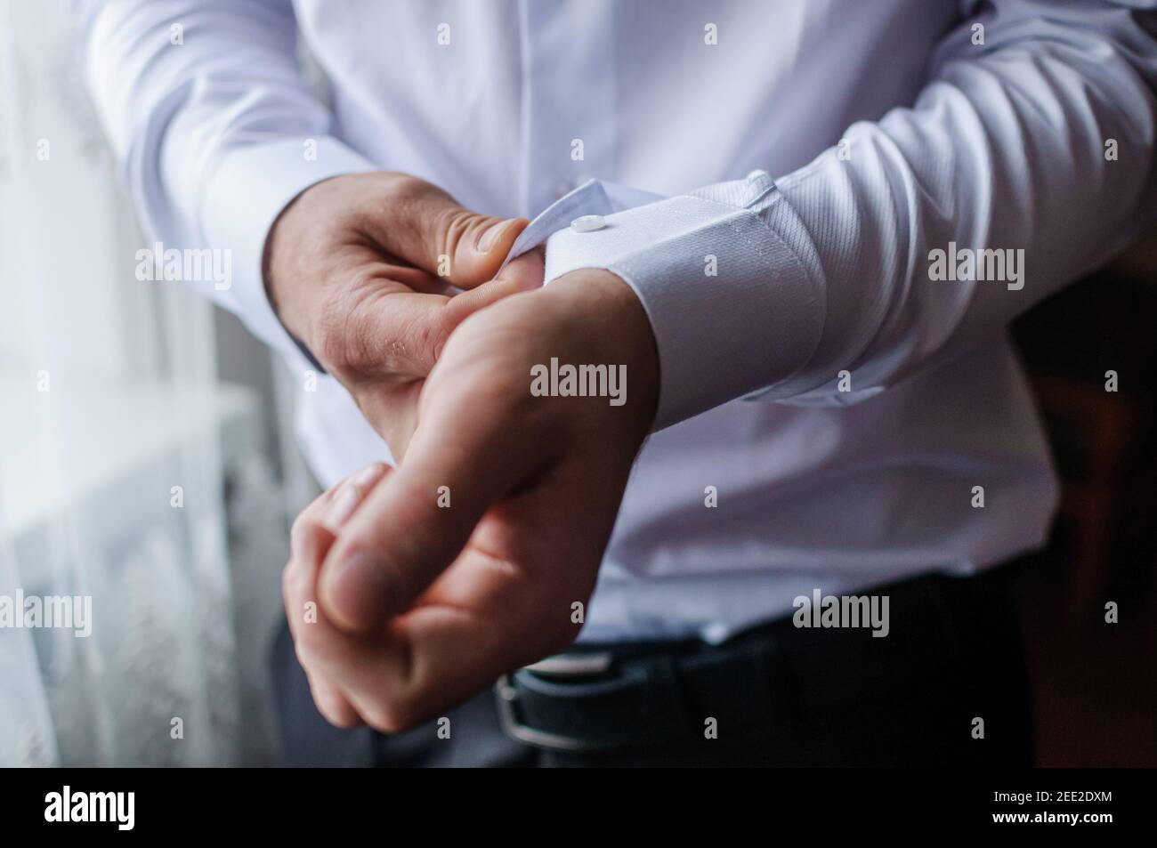 Der Bräutigam befestigt einen Knopf auf dem Ärmel seines hemd Stockfoto
