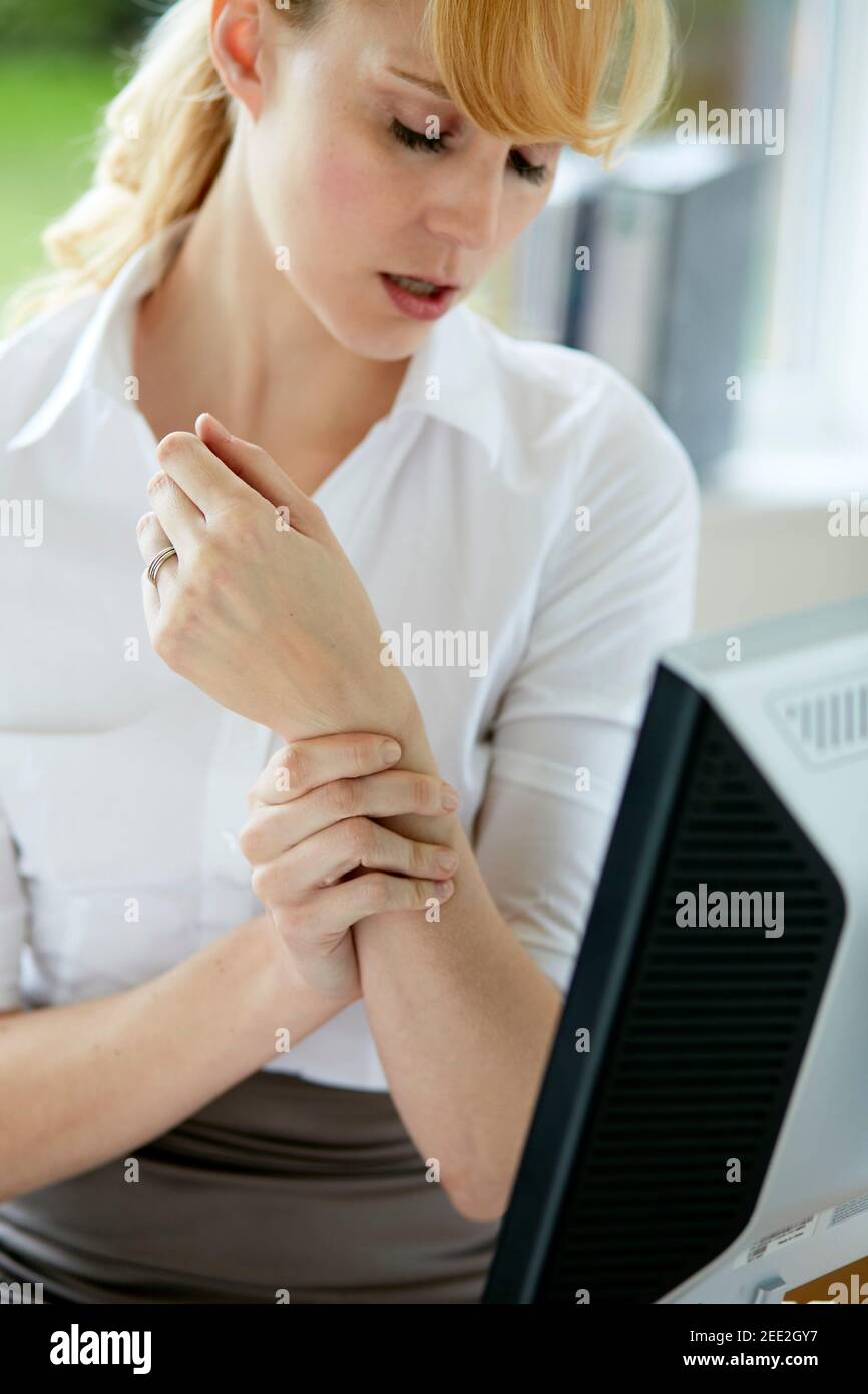 Frau hält ihr schmerzhaftes Handgelenk Stockfoto