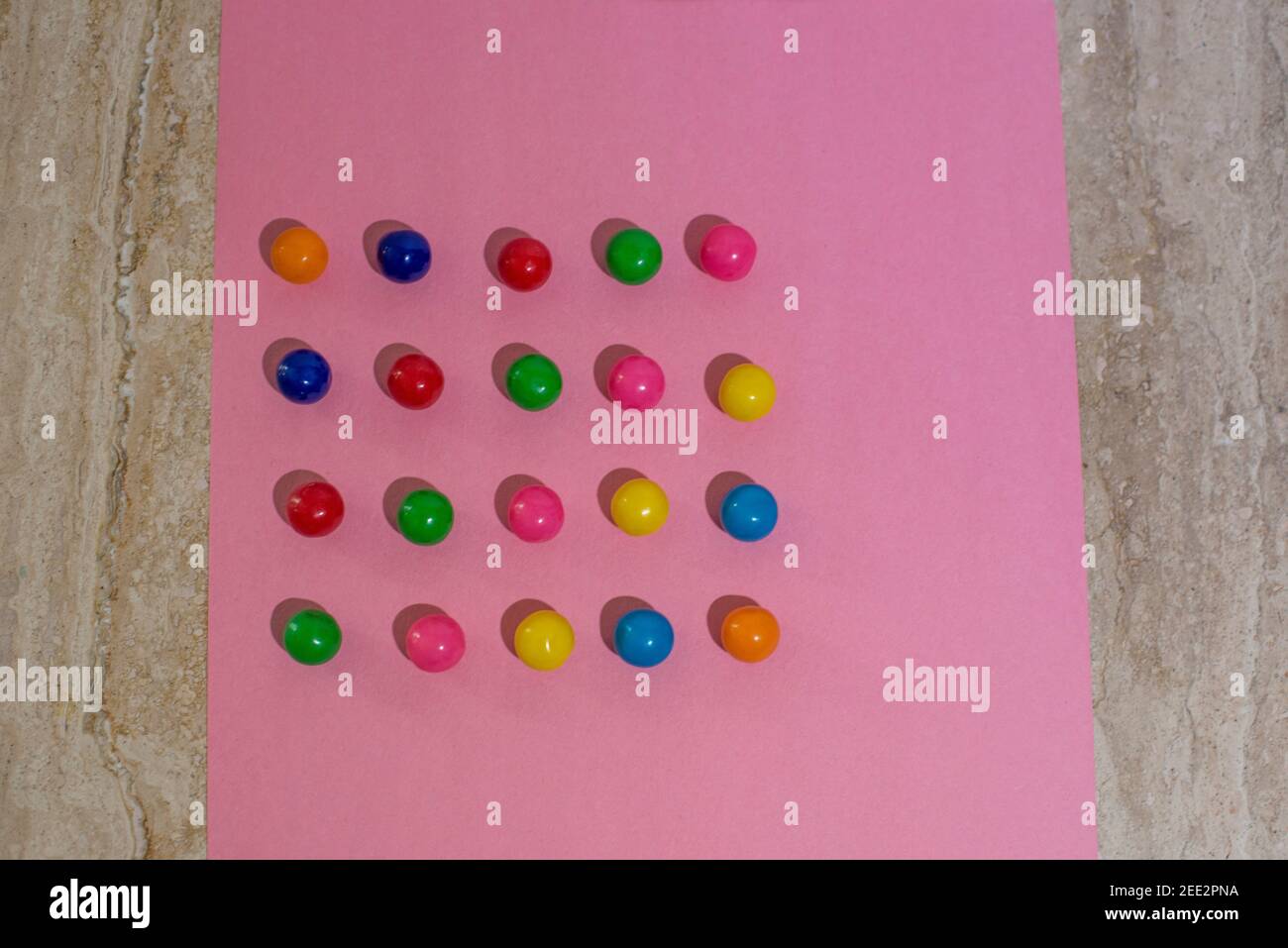 Candy ist auf buntem Papier angeordnet, wodurch sich wiederholende Muster entstehen. Serie. Stockfoto