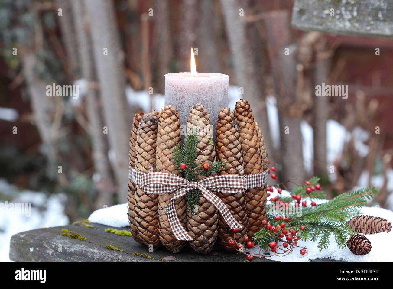 weihnachtsdekoration mit Kerze und Tannenzapfen Stockfoto