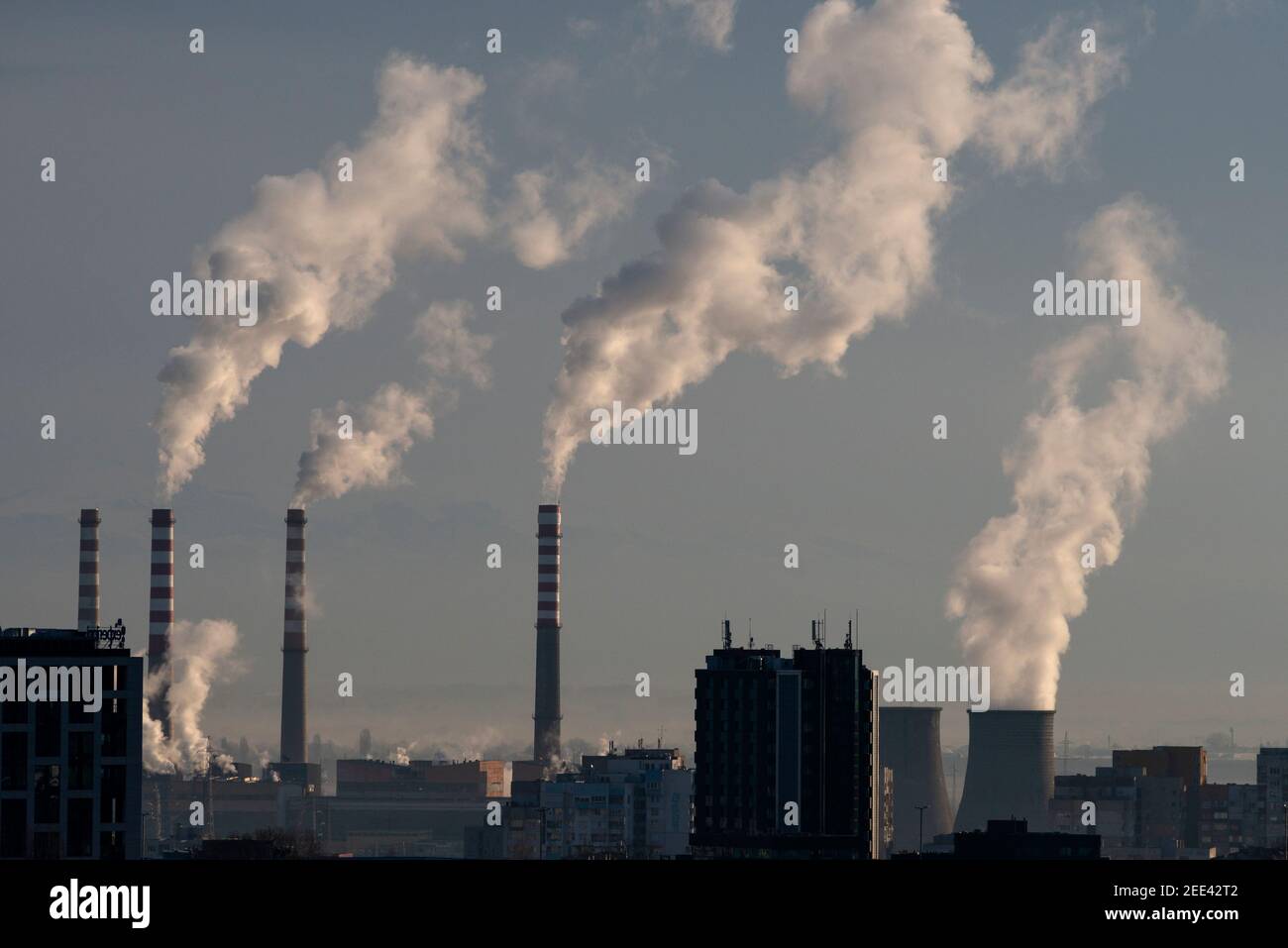 Verschmutzungskonzept Gegenüberstellung von Rauchschornsteinen, rauchenden Schornsteinen und dunklen Gebäuden in Sofia Bulgarien Osteuropa EU ab Januar 2021 Stockfoto