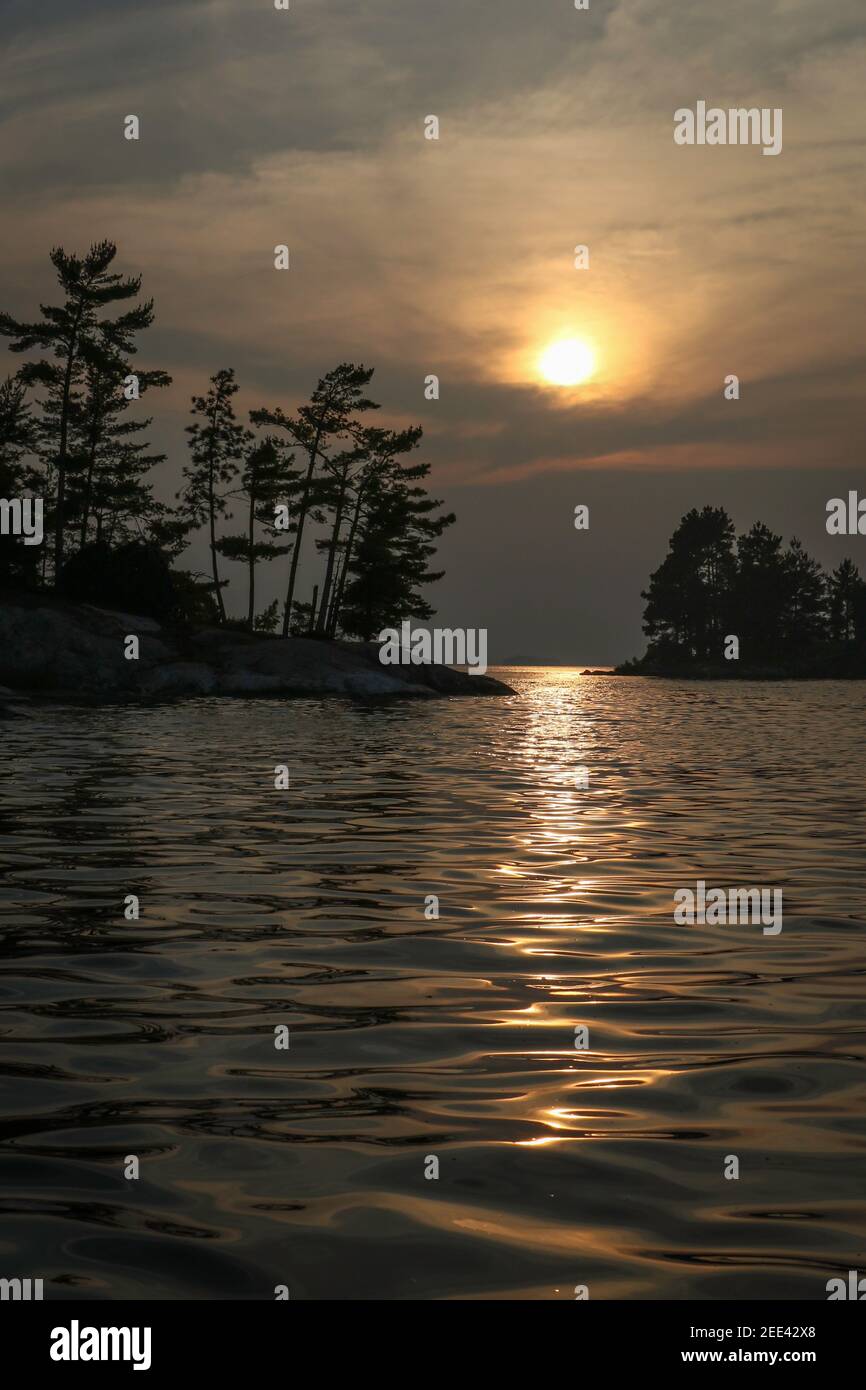 Abendsonne reflektiert aus dem ruhigen Wasser von 'Kabetogama See,. Voyageurs National Park, Minnesota, USA Stockfoto
