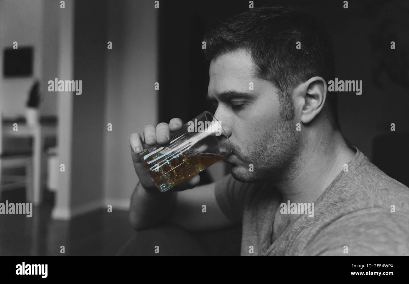 Erschöpfter betrunkener Mann mit Glas Whisky. Alkoholismus Konzept. Stockfoto