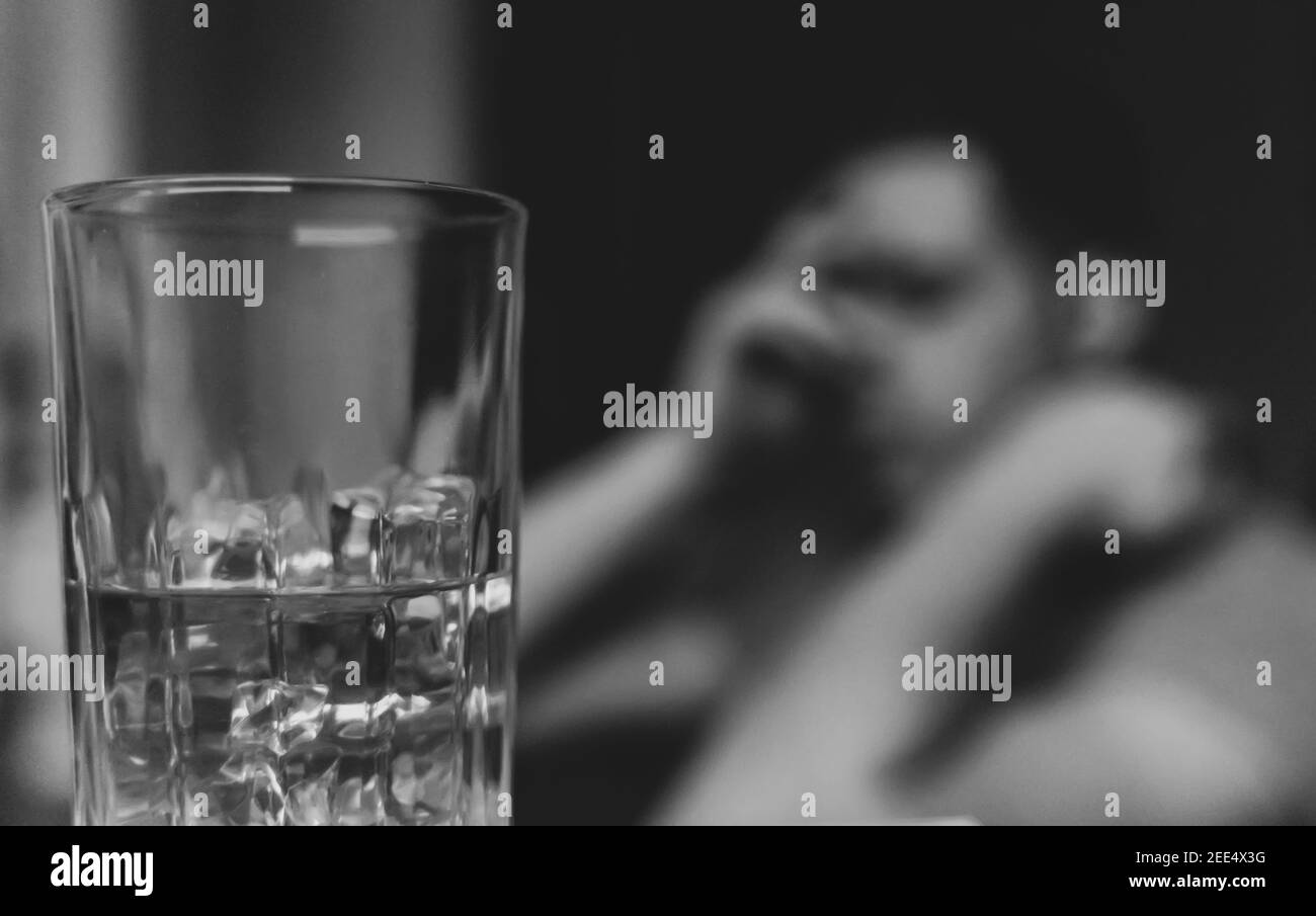 Erschöpfter betrunkener Mann mit Glas Whisky. Alkoholismus Konzept. Stockfoto