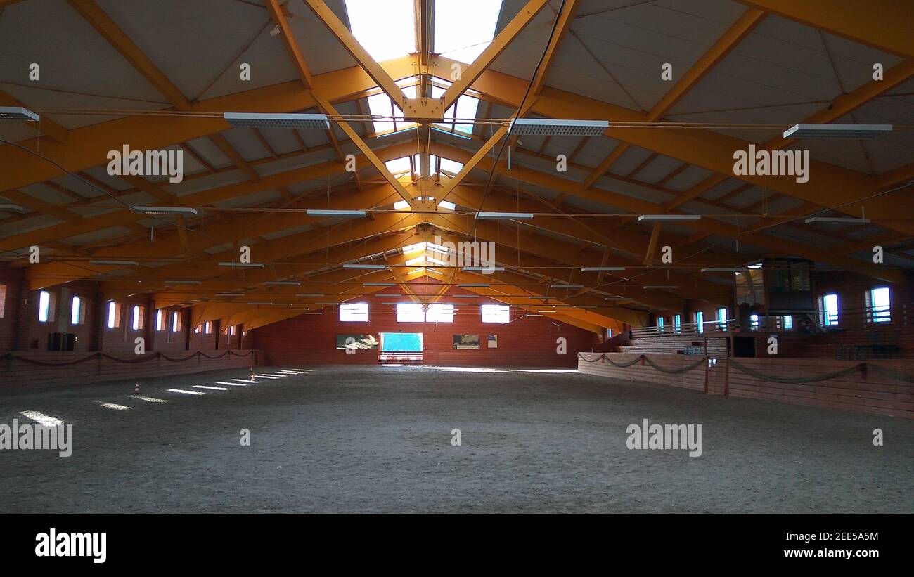 Foto einer leeren Reithalle für Pferde und Reiter. Die Reitschule ist für Dressur- und Springpferde den ganzen Tag geeignet Stockfoto