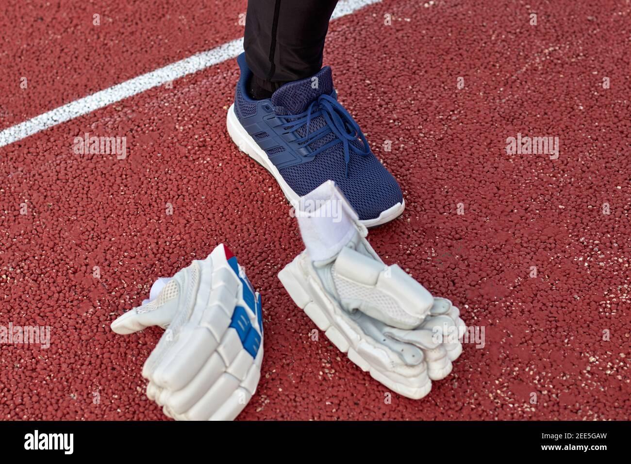 Weiße Cricket-Handschuhe links auf dem Platz bei der Spieler Fuß Stockfoto