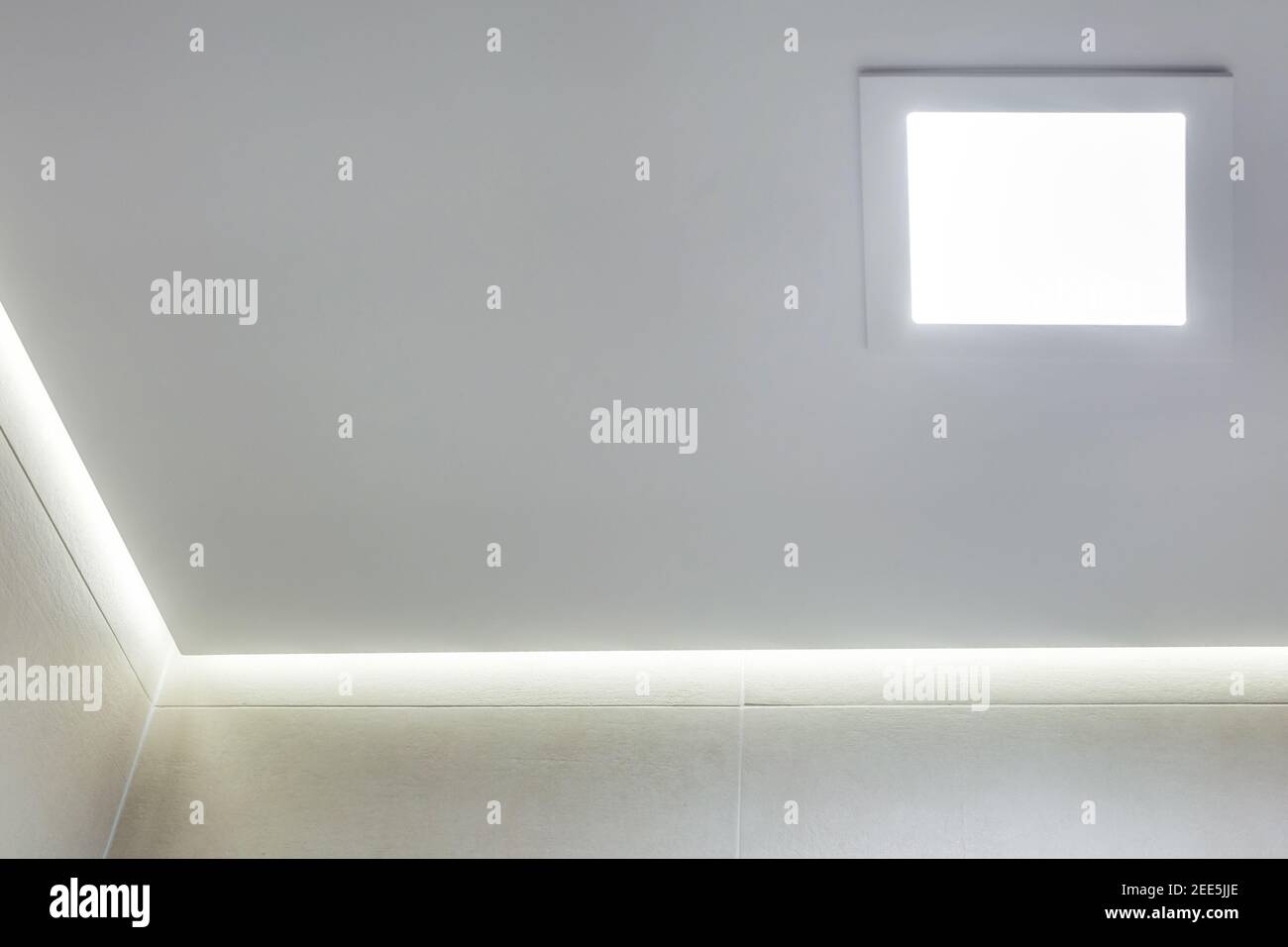 Abgehängte Decke mit Halogenstrahlern und Trockenmauerkonstruktion im leeren Raum in Wohnung oder Haus. Stretchdecke weiß und komplex. Stockfoto