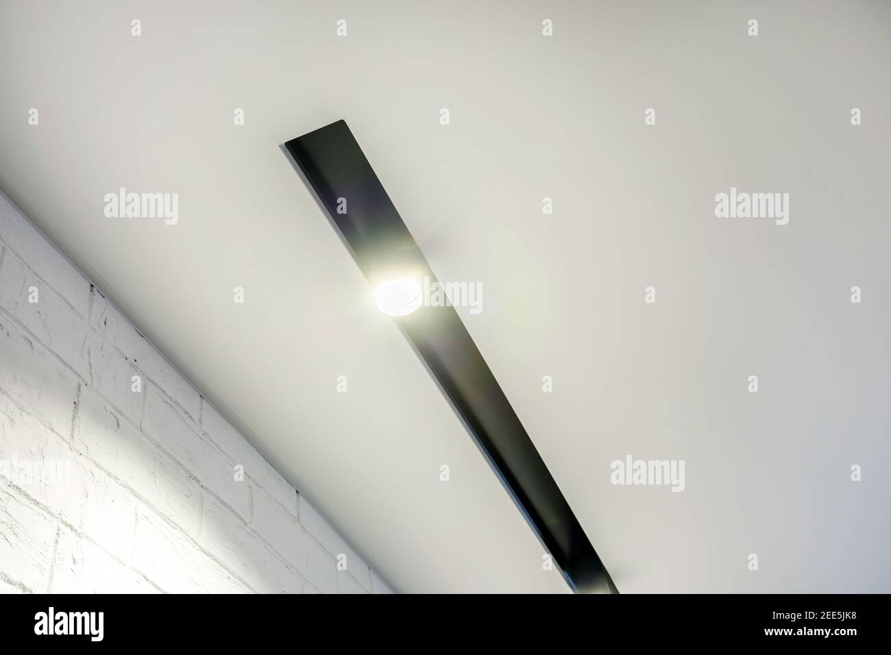 Abgehängte Decke mit Halogenstrahlern und Trockenmauerkonstruktion im leeren Raum in Wohnung oder Haus. Stretchdecke weiß und komplex. Stockfoto