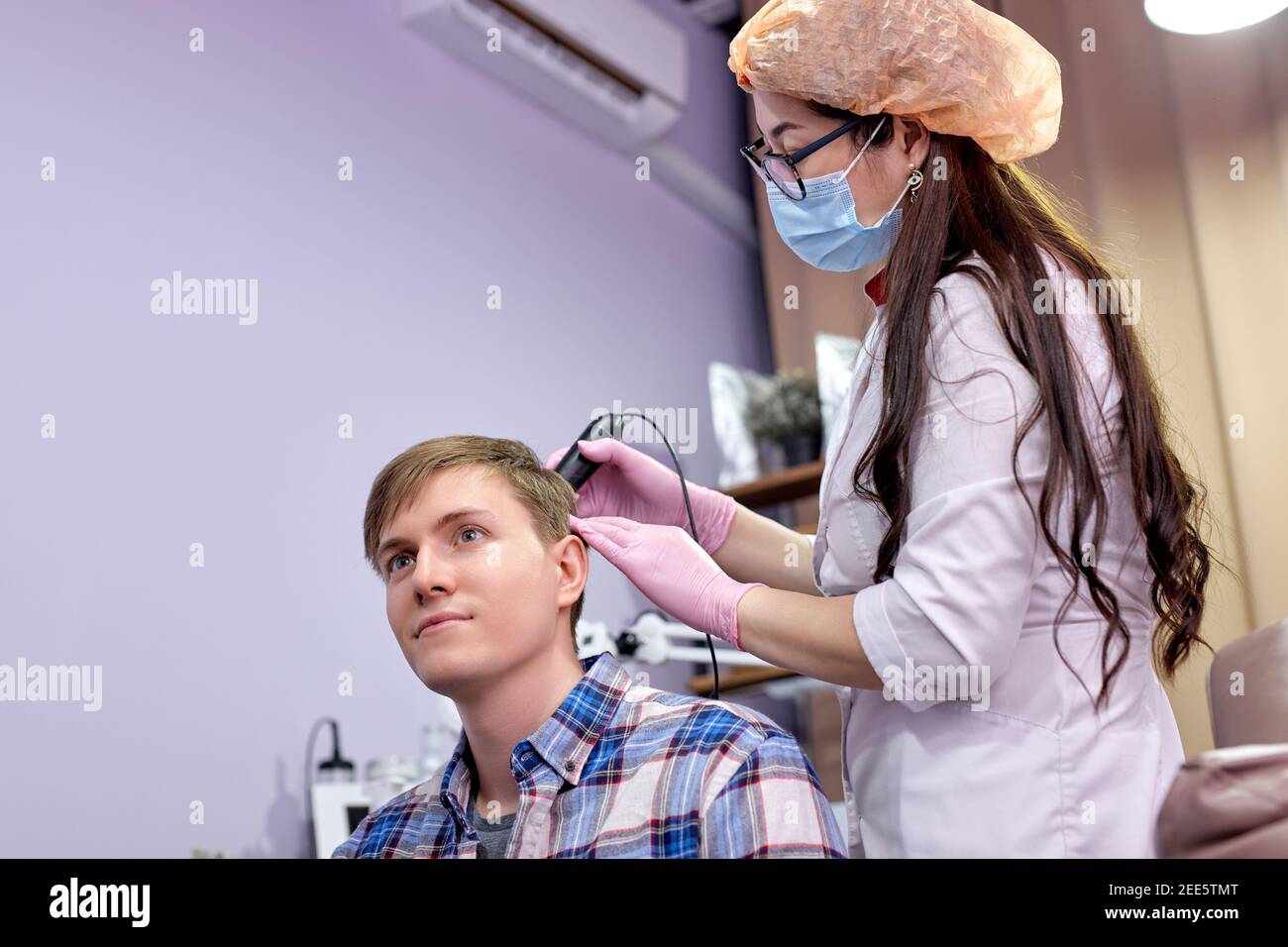 Der Arzt Dermatologe diagnostiziert die Struktur des Haares des Menschen  mit dem speziellen Werkzeug - dem Trichoskop. Trichologie, Trichogramm.  Medizin und Schönheitskonzept Stockfotografie - Alamy