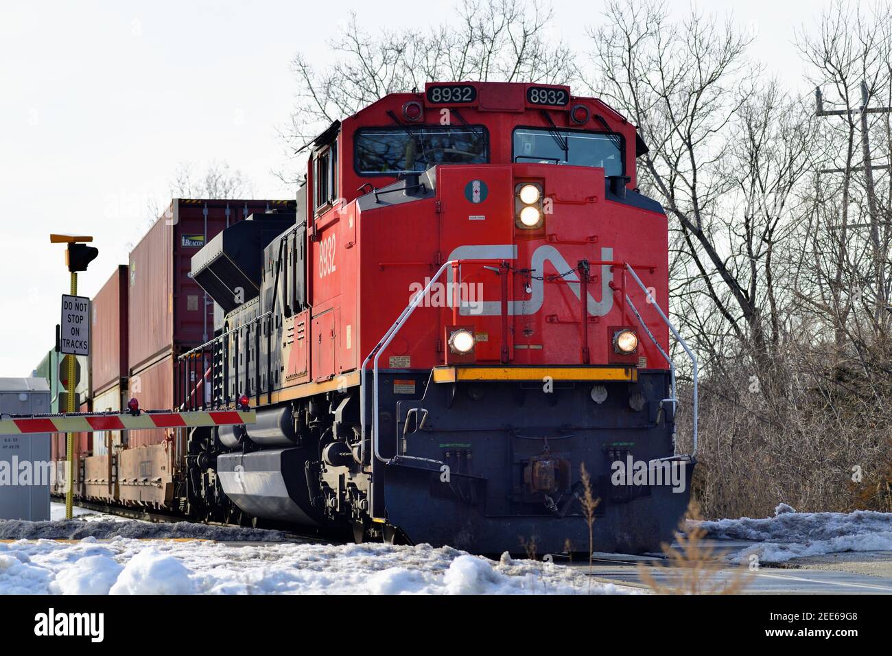 Barrington, Illinois, USA. Eine Canadian National Railway Lokomotive führt einen intermodalen Güterzug nach Norden durch eine Straßenkreuzung. Stockfoto