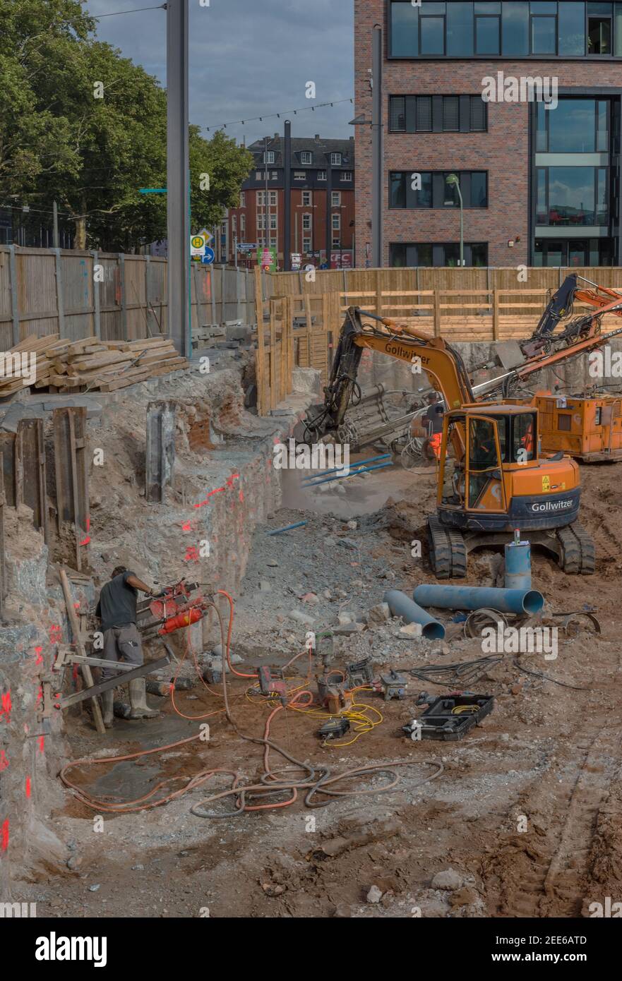 Arbeiter im Fundamentgraben mit Baumaschinen auf dem Baustelle Stockfoto