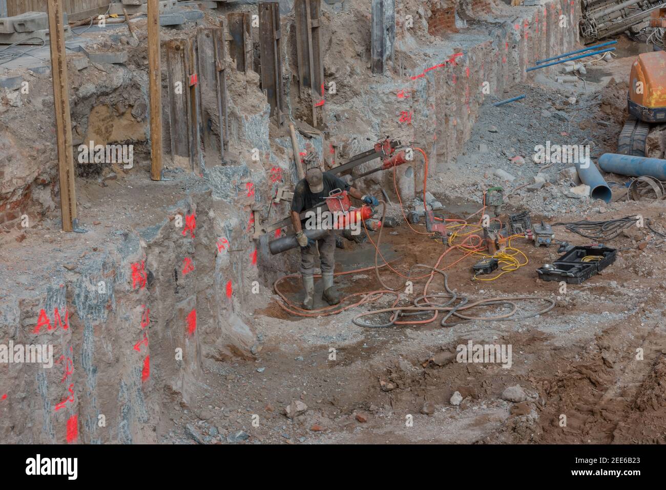 Arbeiter im Fundamentgraben mit Baumaschinen auf dem Baustelle Stockfoto