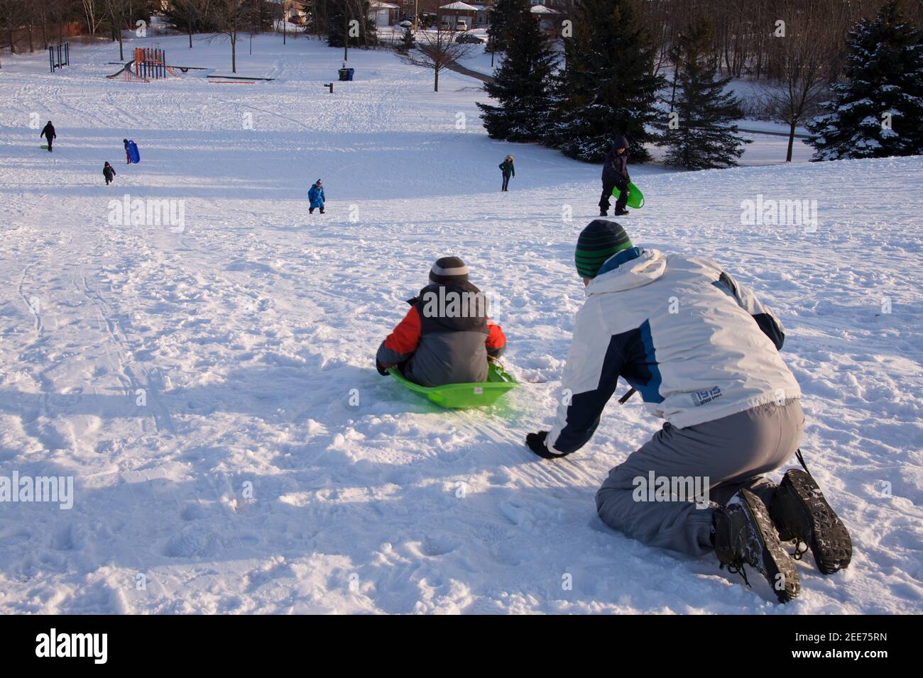 Wintersport-Rodeln - reifer Gesundheitsvater und Sohn spielen Rodeln, Winter, draußen, gesunder Lebensstil. Stockfoto