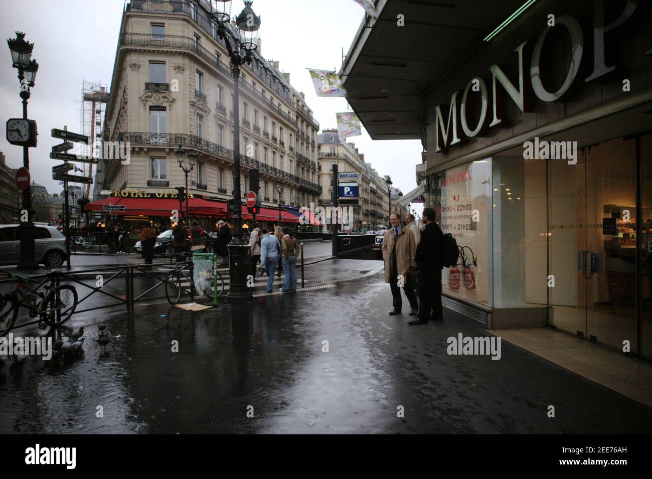 AJAXNETPHOTO. MÄRZ 2006, 30TH. PARIS, FRANKREICH. - REGENTAG IN DER STADT - CAFE RESTAURANT ROYAL OPERA AN DER KREUZUNG DER AVENUE DE L'OPERA (LINKS) UND RUE SAINT ROCHE (RECHTS) VOM EINGANG ZUM MONOPRIX KAUFHAUS. FOTO: JONATHAN EASTLAND/AJAX REF: R63003_182 Stockfoto