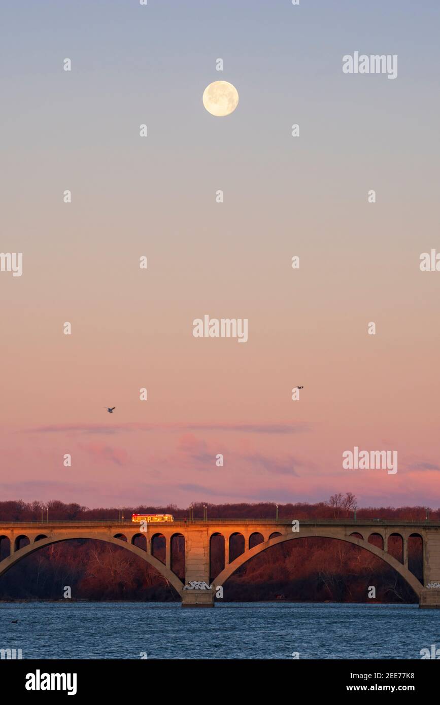Der Vollmond geht im frühen Morgenlicht über der Key Bridge in Washington, DC, unter. Stockfoto