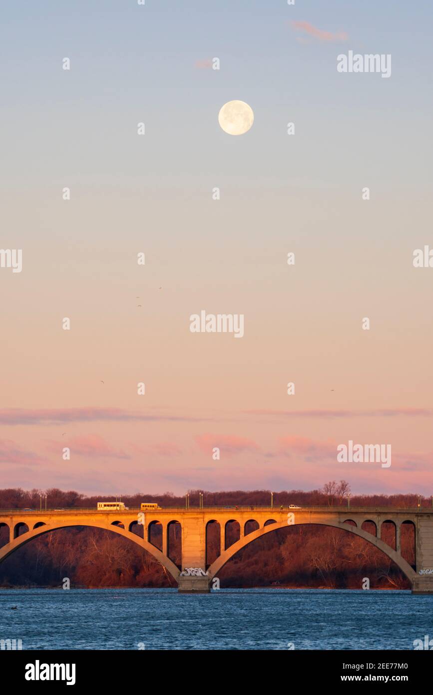 Der Vollmond geht im frühen Morgenlicht über der Key Bridge in Washington, DC, unter. Stockfoto