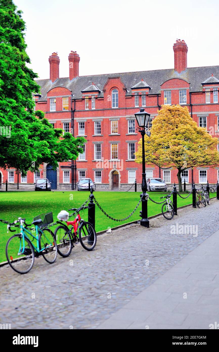 Fahrräder und Grün führen zu den Rubriken am Library Square auf dem Campus-Viereck des Trinity College in Dublin. Die rotgemauerte Rubrik stammt aus dem Jahr 1700 Stockfoto