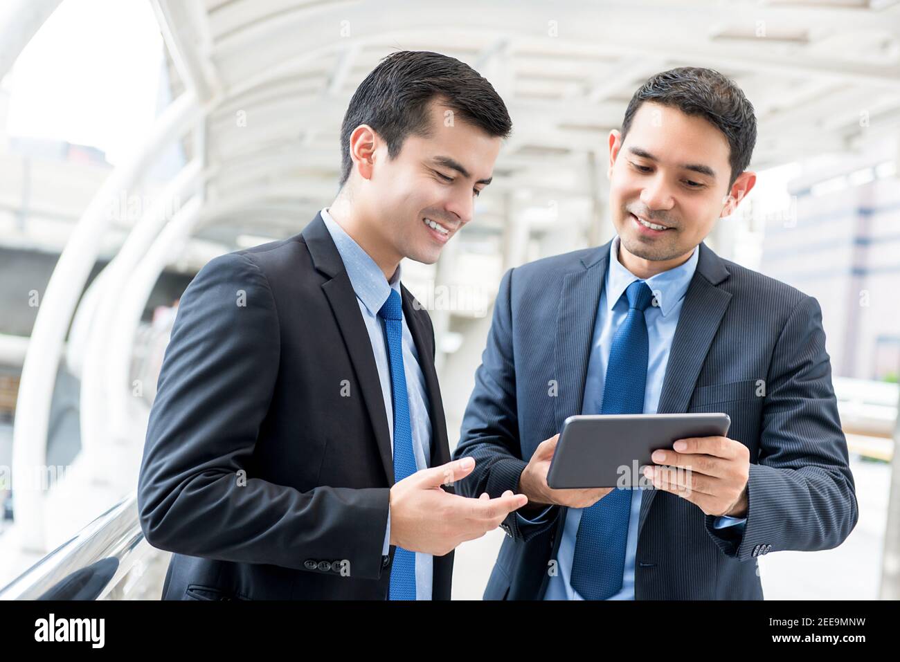 Junge schöne Unternehmer diskutieren Projekt auf digital Tablet Computer im Freien Stockfoto